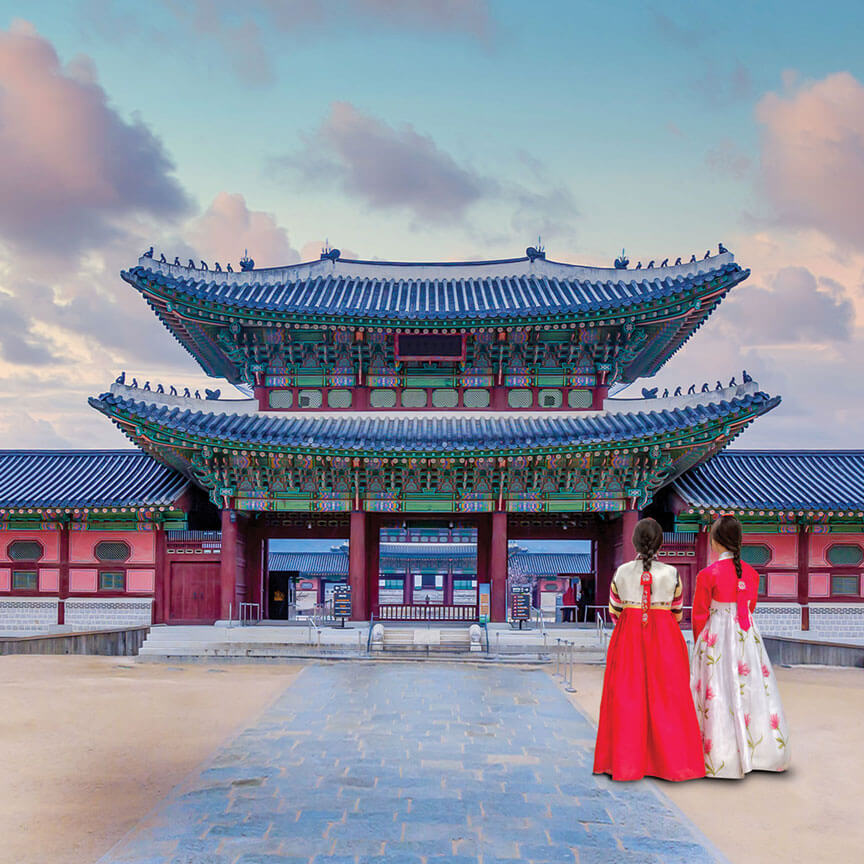 women in hanboks in front of Korean palace